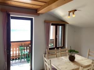 ein Esszimmer mit einem Holztisch und einem Balkon in der Unterkunft Privatzimmer am See in Hallstatt