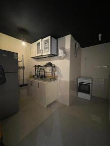 a kitchen with white cabinets and a refrigerator at شقة فاخرة بقفل ذكي - Luxury apartment in Riyadh