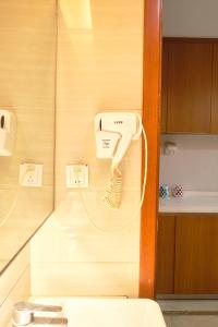 um telefone pendurado numa parede ao lado de um WC em Guangzhou Uhome Service Apartment em Guangzhou