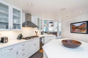 a kitchen with white cabinets and a wooden bowl on a counter at Ice House 317 condo in Telluride