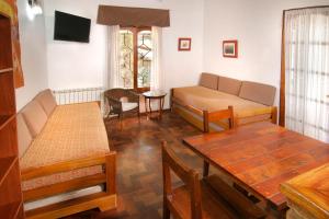 ein Wohnzimmer mit einem Sofa und einem Tisch in der Unterkunft Hostal La Merced in Villa General Belgrano