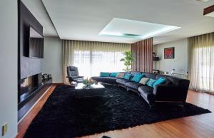 a living room with a black couch and a fireplace at Fonte Seca GuestHouse in Leiria