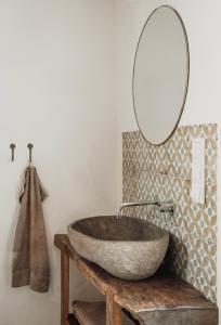 La salle de bains est pourvue d'un lavabo en pierre et d'un miroir. dans l'établissement Três Figos, à São Luis