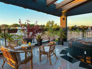 une terrasse avec des chaises, une table et une grande fenêtre. dans l'établissement Gilboa cliff eclectic villa- heated swimming pool, à Nurit