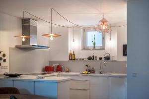 a kitchen with white cabinets and a sink at Ferienwohnung Tödiblick in Wangen im Allgäu