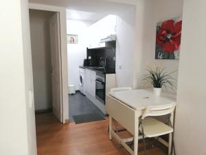 une petite cuisine avec une table blanche et une cuisinière dans l'établissement Flowers in Pop House, à Lisbonne