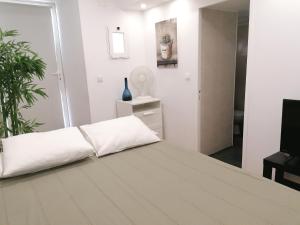 - une chambre blanche avec un lit et un miroir dans l'établissement Flowers in Pop House, à Lisbonne