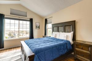 1 dormitorio con cama azul y ventana grande en Fountain Retreat with Private Hot Tub and Fire Pit, en Fountain