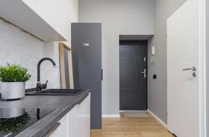 a kitchen with a sink and a hallway with a door at Kawalerka w Śródmieściu 24 in Łódź