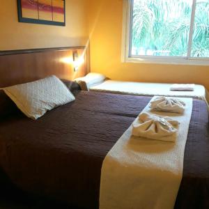 Habitación de hotel con 2 camas y ventana en Saint Tropez hotel en Villa Carlos Paz