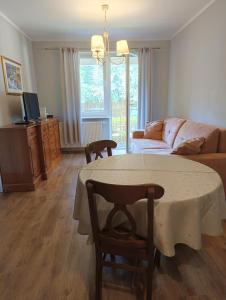 ein Wohnzimmer mit einem Tisch und einem Sofa in der Unterkunft Apartament Parkowy 24h in Łomża