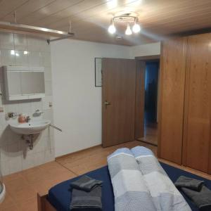 a bathroom with a bed and a sink in a room at Ferienwohnung Patrycja in Weissenbach am Lech