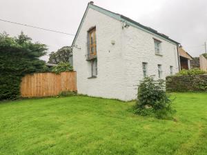 una casa blanca con una valla y un patio en Y Cartws, en Eglwyswrw