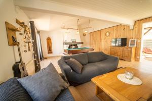 uma sala de estar com um sofá e uma mesa em Oleron Surf House em Allards