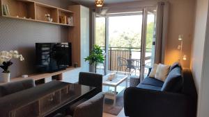 a living room with a couch and a television and a balcony at Apartament Azul in Cieszyn