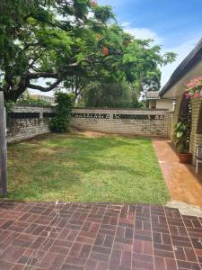 a backyard with a brick fence and a yard with grass at Guesthouse in fantastic location in Brisbane