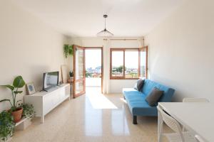 a living room with a blue couch and a tv at Blu Mare apartment in Peñíscola