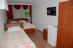 Habitación pequeña con 2 camas y ventana en GOLD OTEL KASTAMONU, en Kastamonu