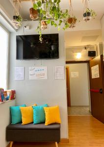 a living room with a couch with yellow and blue pillows at Hotel Big Bang in Rome