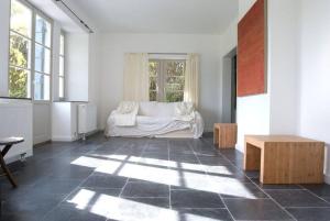 sala de estar con sofá blanco y ventana en Le Chaperon Villa, en Tellin