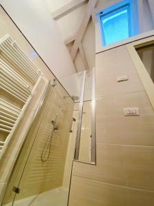 W łazience znajduje się prysznic ze szklanymi drzwiami. w obiekcie ATTICO61 w Arco