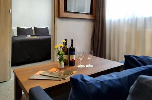 una habitación con una mesa con botellas de vino y copas en Kolejarz Best For You SPA, en Ustroń