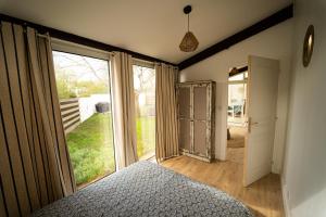 um quarto com uma cama e uma grande janela em Oleron Surf House em Allards