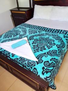 a bed with a blue and black comforter on it at Groupe appart-La casa de Wael in Ifrane