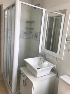 ダーバンにあるSea Lodge G01の洗面台と鏡のある白いバスルーム +37枚の写真