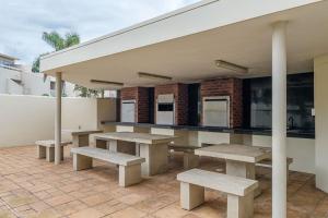 un grupo de mesas de picnic en un patio en Sea Lodge G01 en Durban