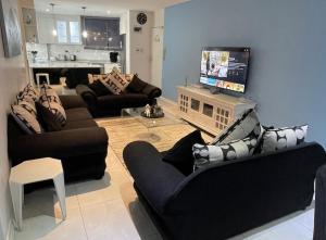 a living room with couches and a flat screen tv at Sea Lodge G01 in Durban