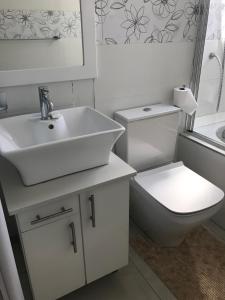 Baño blanco con lavabo y aseo en Sea Lodge G01 en Durban