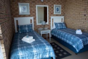 a bedroom with two beds and a mirror at 7 Eagles View in Jeffreys Bay