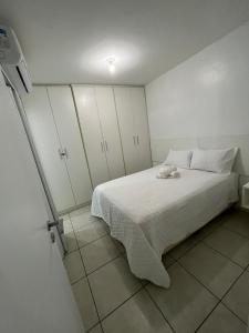 een slaapkamer met een wit bed en witte kasten bij Apartamento em Maceió a beira mar in Maceió