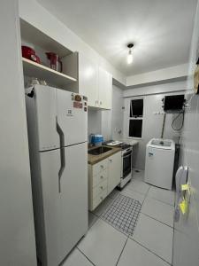 een witte keuken met een koelkast en een wastafel bij Apartamento em Maceió a beira mar in Maceió
