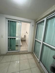 een kamer met glazen schuifdeuren en een kamer met een slaapkamer bij Apartamento em Maceió a beira mar in Maceió