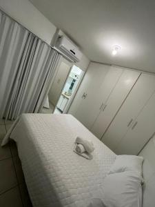 een wit bed met een ring erop bij Apartamento em Maceió a beira mar in Maceió