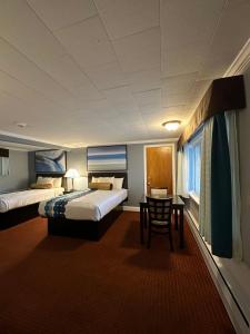 um quarto de hotel com duas camas e uma mesa em Rodeway Inn Orleans - Cape Cod em Orleans