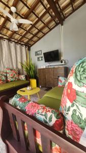 een woonkamer met een bank en een tv bij Hostel Caminho da Praia in Arraial do Cabo
