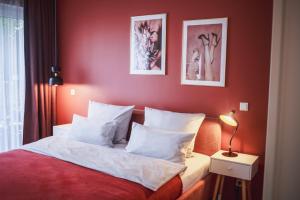 a bedroom with red walls and a bed with white pillows at The Circus Apartments in Berlin