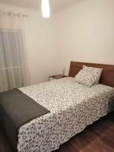 - une chambre avec un lit et une couette noire et blanche dans l'établissement Moradia no Meco, à Sesimbra