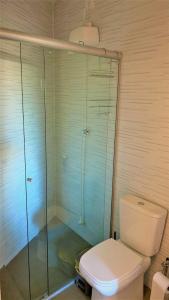 een badkamer met een toilet en een glazen douche bij Loft Veneto in Maringá