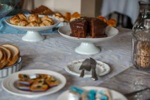 una mesa con platos de repostería y un pastel de chocolate en Villa da Esperança, en Campos do Jordão