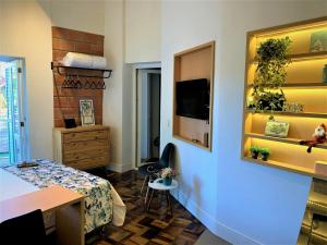 een kamer met een bureau en een kamer met een tafel bij Loft Veneto in Maringá