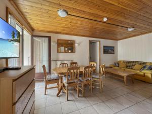 a dining room with a table and chairs and a couch at Appartement 5/6 Pers centre Carroz (ARB 40) in Les Carroz d'Araches