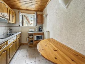 a kitchen with wooden cabinets and a wooden table at Appartement 5/6 Pers centre Carroz (ARB 40) in Les Carroz d'Araches +3 photos