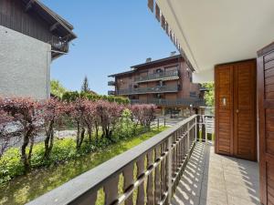 a balcony with a fence and trees and a building at Appartement 5/6 Pers centre Carroz (ARB 40) in Les Carroz d'Araches