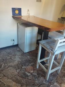 a wooden table and a chair and a refrigerator at Disfruta como local in Mendoza