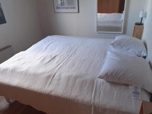 a bed with white sheets and pillows in a bedroom at Holiday home Rødvig Stevns II in Rødvig