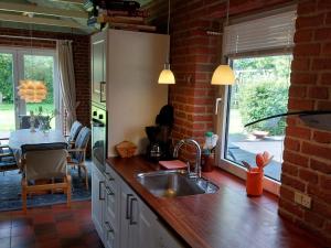 a kitchen with a sink and a brick wall at Holiday home Sydals XCIV in Skovmose